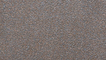 Aufkleber - A grey and brown surface with a few small specks of color. The surface is rough and uneven