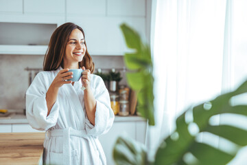 Wall Mural - Woman Enjoying Morning Coffee in a Bright, Cozy Kitchen