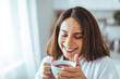 © Dragana Gordic - Woman Smiling While Enjoying a Relaxing Cup of Tea at Home