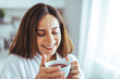 © Dragana Gordic - Smiling Woman Enjoying Morning Tea in Cozy Home Setting