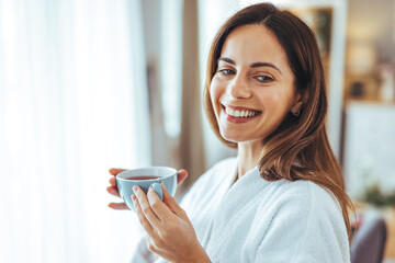 Wall Mural - Smiling Woman Enjoying Morning Tea in Cozy Home Environment