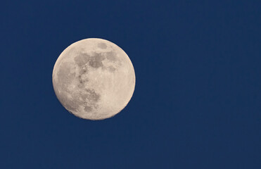 full moon over a blue sky at sunset