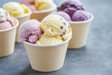 Sticker - A group of colorful ice cream cups arranged on a table, perfect for a party or outdoor event