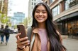 © Ace64 Studio - Smiling cool teen girl holding mobile cell phone having fun outdoors with cellphone in hands.