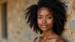 © Trust Fish - Natural portrait of an Ethiopian woman with curly hair and no makeup leaning against a rustic stone wall