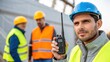 © DigitalSpace - A medium closeup shot of communication between crew members with one worker holding a twoway radio while surveying the area for safe installation.