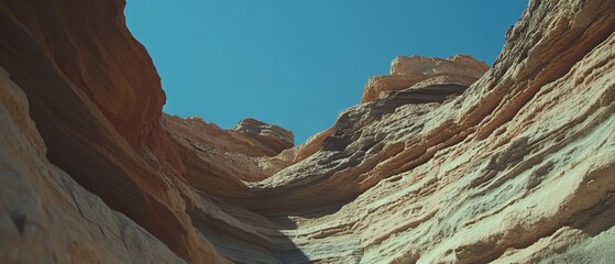 Aufkleber - Layered rock formations with distinct strata and varied textures under clear blue sky