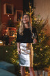 © blackday - Woman in Metallic Silver Skirt and Blank Black T-shirt Posing by Christmas Tree