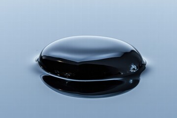 Leinwandbilder - Close up view of a single black oil drop reflecting light in a clear environment during daylight. Generative AI