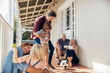 © Marko Geber - Happy multigenerational family playing together on the porch