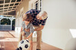 © Marko Geber - Grandfather and grandson playing with soccer ball on the porch