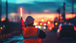 © BURINKUL - Road construction zone with a worker holding a glowing baton, directing traffic safely at dusk