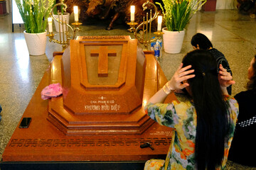 Wall Mural - Tac Say Church, also known as Father Diep Church.  Francis Xavier Truong Buu Diep was a famous  Vietnamese Catholic priest killed in 1946.  Faithful praying at his grave. Bac Lieu. Vietnam. .