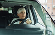 © Davor - Senior businesswoman driving a car on the road