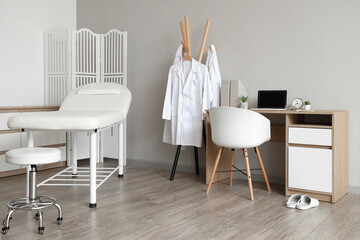 Sticker - Interior of medical office with couch, clothes rack and doctor's workplace