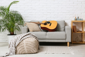 Wall Mural - Modern acoustic guitar on grey sofa in stylish living room