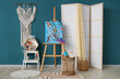 © Pixel-Shot - Interior of artist's workshop with painting on easel, folding screen and art supplies
