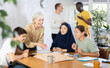 © JackF - Group of multiethnic people playing board game at table in office