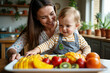 © Aleksei Solovev - A mother and her baby are in a kitchen, engaging with a tray of colorful fruits and vegetables.