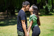 © Mariano - Latin couple kissing in a park on a sunny day