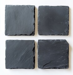 Wall Mural - Four square dark gray slate coasters on white background.