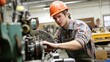 © wahyu bsbt - Young male apprentice operating industrial machinery in a workshop.