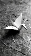 Aufkleber - A meticulously folded paper crane rests gracefully on a textured surface, highlighting the beauty of handmade crafts. This tranquil moment evokes creativity and harmony in its minimalist design