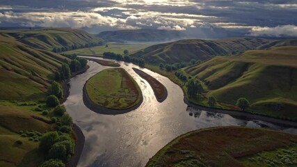 Aufkleber - Serene river winding through lush hills in a tranquil landscape at dusk displays nature's beauty and serenity