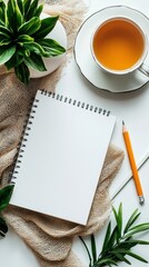 Poster - Nestled among greenery, a blank notebook lies on soft fabric, accompanied by a steaming cup of tea. Perfect for inspiring creativity during a serene afternoon moment
