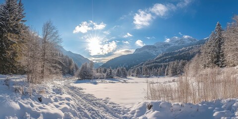 Wall Mural - Serene winter landscape featuring snow-covered mountains and a bright blue sky with sun rays illuminating a tranquil frozen lake and trees