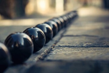 Poster - A line of black balls resting on the edge of a city sidewalk