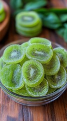 Wall Mural - Freshly sliced kiwis arranged in a bowl surrounded by lush green leaves