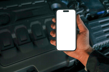 Aufkleber - Hand holding a smartphone with a blank screen in front of an open car hood, showing the engine compartment. Concept for car diagnostics, automotive apps, or remote vehicle monitoring