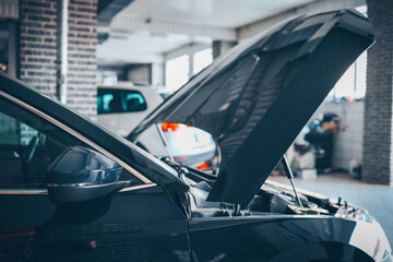 Poster - Blue car with an open hood in a garage. Concept for automotive diagnostics, repair, and service in a professional workshop environment