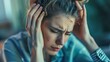 © Bashir - Young Woman with Headache Holding Temples, Stress, and Depression