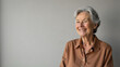 © Georgiy - Elderly gray-haired beautiful happy woman in a Mocha Mousse colored blouse on a light background