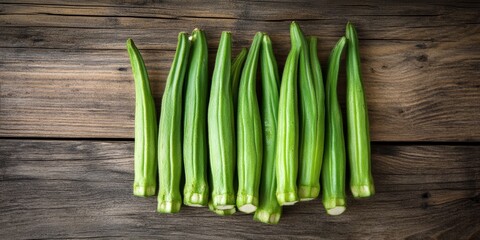 Poster - Fresh bunch of lady fingers or okra displayed on a rustic wooden background, highlighting the vibrant green color and unique texture of the lady fingers or okra for culinary purposes.