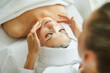 © Studio Romantic - Professional cosmetologist at a spa salon applies a cleansing and moisturizing sheet mask on the face of a relaxed young woman. Beauty, facial skin care concept