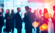© Prasanth - A vibrant networking event with business professionals engaging in conversation, blurred figures creating a sense of motion and activity
