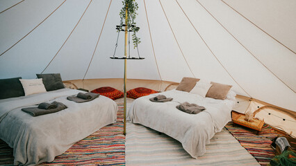 A tent with two beds and a table in the middle