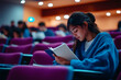 © Prasanth - Focused university student taking notes during lecture in auditorium