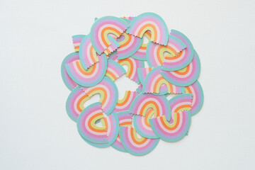 Wall Mural - die-cut rainbow confetti arranged in circle on paper