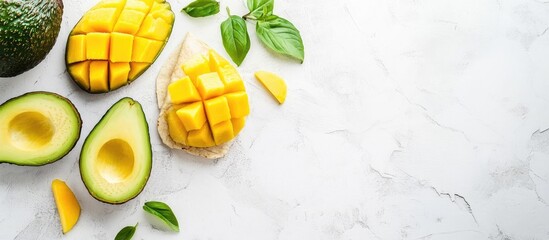 Aufkleber - Fresh mango and avocado halves arranged on a marble surface with green leaves and copy space for text.