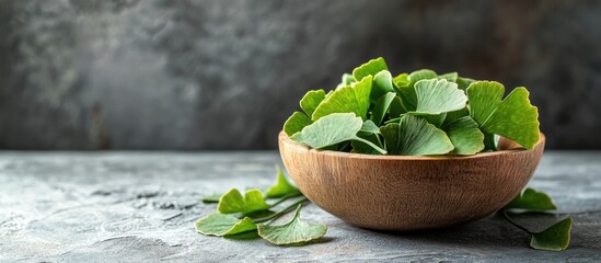 Poster - Fresh green herb leaves in wooden bowl on textured gray background with copy space