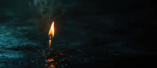 Poster - Single lit candle flame flickering in dark environment with smoke against blurred background and shallow water surface illustrating tranquility Copy Space