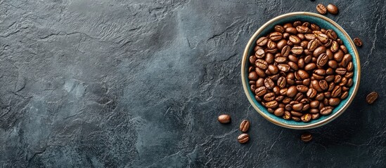 Poster - Coffee beans in a blue bowl on textured dark background with copy space for text. High-quality roasted coffee bean image.