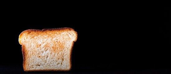 Poster - Freshly toasted bread slice on black background with copy space for text or design elements.