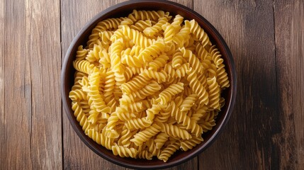 Aufkleber - Bowl of uncooked fusilli pasta on wooden surface with ample copy space for text placement