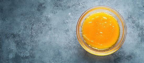 Poster - Bowl of raw egg yolk on textured blue surface with Copy Space for text placement