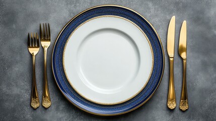 Poster - Elegant gold cutlery and a blue-patterned plate set on a textured gray surface with Copy Space for text placement.